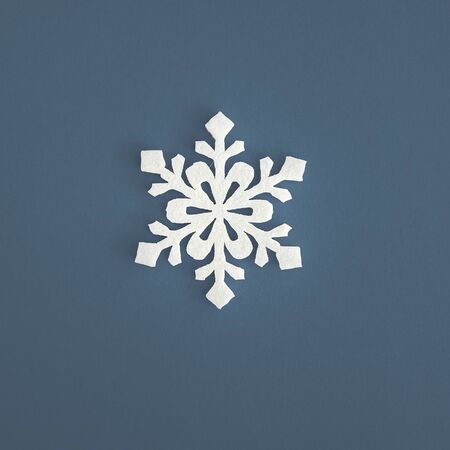 Christmas holidays composition, top view white snowflakes decoration on blue-gray background with copy space for text. Flat lay. Winter, postcard template.の写真素材