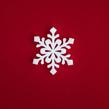 Christmas holidays composition, top view white snowflakes decoration on red background with copy space for text. Flat lay. Winter, postcard template.の写真素材