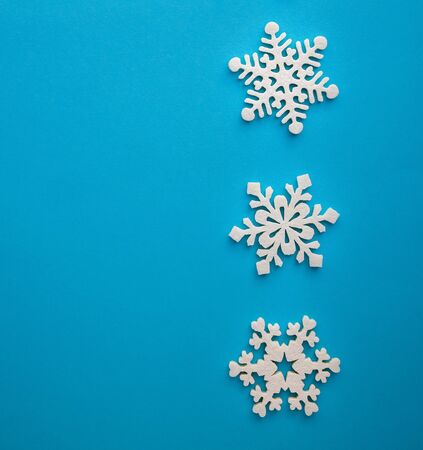 Christmas holidays composition, top view white snowflakes decoration on a blue-aquamarine background with copy space for text. Flat lay. Winter, postcard templateの写真素材