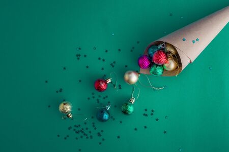Christmas holidays composition, top view of craft cone showered with colorful balls on a blue-green background with copy space for text. Flat lay. Winter, postcard templateの写真素材