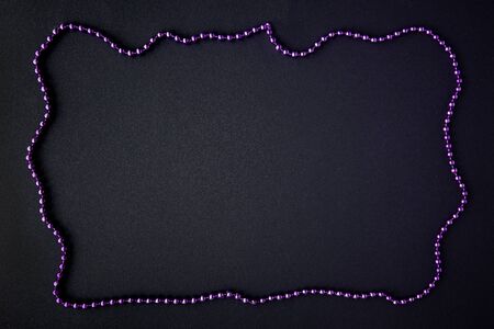 On a dark background are laid Christmas beads in the form of a frame with copy space. Postcard Templateの写真素材