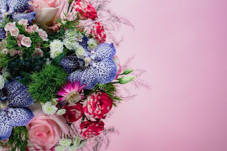 stylish trendy delicate bouquet with a variety of spring flowers, roses, orchids in a round box on a pink background. Copy spaceの写真素材