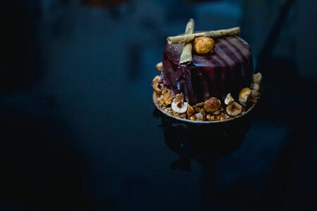 Luxury chocolate cake-cake decorated with a golden decor of caramelized popcorn on a dark background. Flat lay. Close-up. Copy spaceの写真素材