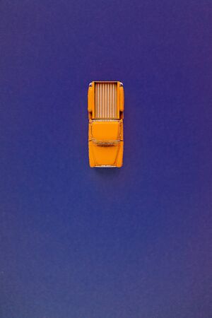 Yellow Retro car pickup on a blue-purple background. Top view with copy space. Flat layの写真素材