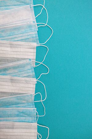 Medical disposable face masks on a blue background. coronavirus covid 19. World pandemic coronavirus. Stop the pandemic. Health and prevention of influenza and an infectious outbreak. Quarantine. New 2019 nCoV virus.の写真素材
