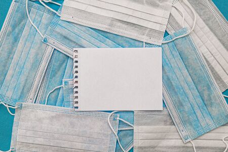 Medical disposable face masks on a blue background with a place for text. coronavirus covid 19. World pandemic coronavirus. Stop the pandemic. Health and prevention of influenza and an infectious outbreak. Quarantine. New 2019 nCoV virus.の写真素材
