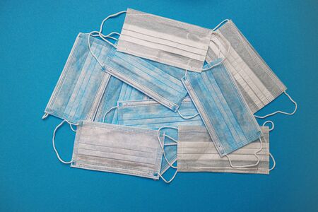 Medical disposable face masks on a blue background. coronavirus covid 19. World pandemic coronavirus. Stop the pandemic. Health and prevention of influenza and an infectious outbreak. Quarantine. New 2019 nCoV virus.の写真素材