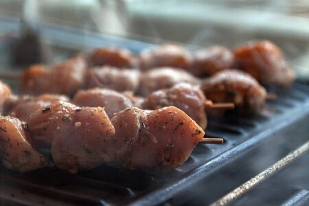 Skewers on skewers from raw meat of pork and beef, chicken cooked on a home electric grill. Top view. Selective focus. Blurの写真素材