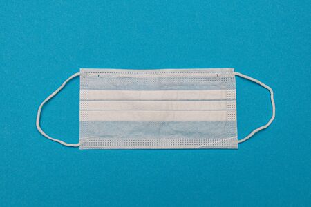 Medical disposable face masks on a blue background. coronavirus covid 19. World pandemic coronavirus. Stop the pandemic. Health and prevention of influenza and an infectious outbreak. Quarantine. New 2019 nCoV virus.の写真素材