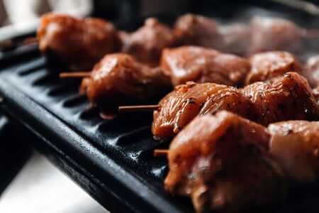 Skewers on skewers from raw meat of pork and beef, chicken cooked on a home electric grill. Top view. Selective focus. Blurの写真素材