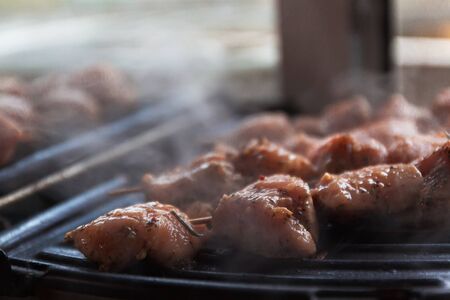 Skewers on skewers from raw meat of pork and beef, chicken cooked on a home electric grill. Top view. Selective focus. Blur.の写真素材