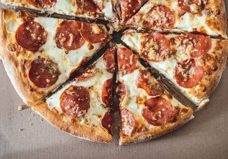 Pizza with pepperoni chopped into pieces in a courtesy box. Selective focus. View from aboveの写真素材