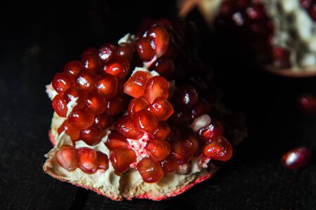 Broken pomegranate fruit on a dark background. close-up. view from above.の写真素材