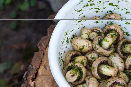 in a bowl raw mushrooms champignons in a marinade with herbs, dill in a rustic natural form. View from above.の写真素材