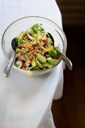 salad in a transparent bowl of avocado, walnuts, green salad, radish French mustard on a table with a white tablecloth. View from aboveの写真素材