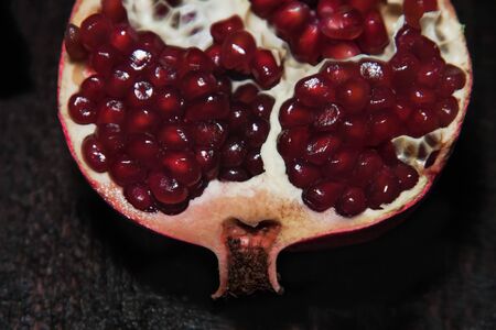 Broken pomegranate fruit on a dark background. close-up. view from aboveの写真素材