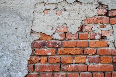 background from the texture of an old brick wall with ruined concreteの写真素材