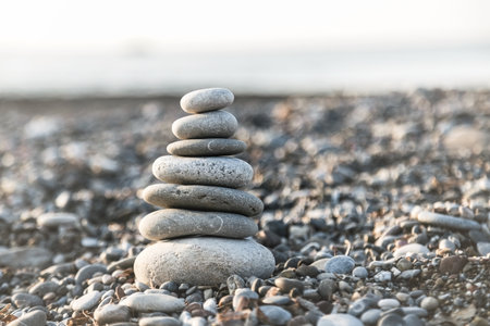 Pyramid of gray pebble stones on the beach of Turkey at sunrise. Zen concept, relaxation. calmness, balanceの写真素材
