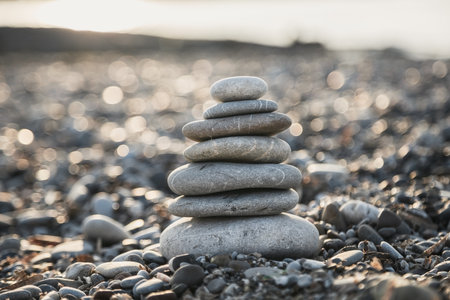 Pyramid of gray pebble stones on the beach of Turkey at sunrise. Zen concept, relaxation. calmness, balanceの写真素材