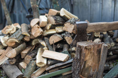 Big ax with chopped woods blurred on background.