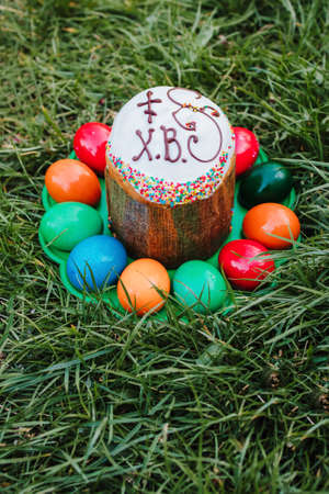 painted and decorative Easter cake and eggs in the grass. Top view, copy spaceの写真素材