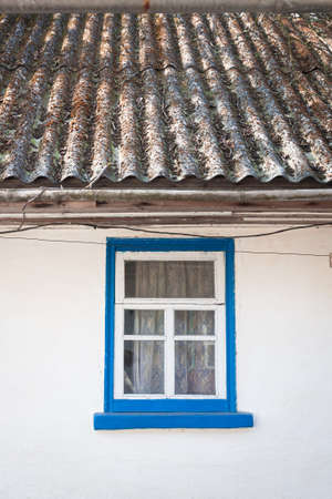 old window outside a rustic white houseの写真素材