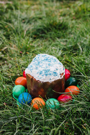 painted and decorative Easter cake and eggs in the grass. Top view, copy spaceの写真素材
