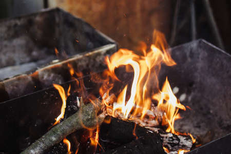 burning firewood in the grill in dark gloomy colors.