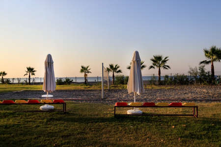 Empty volleyball court with a net at sunset with palm trees and the sea in the Turkish hotel.の写真素材