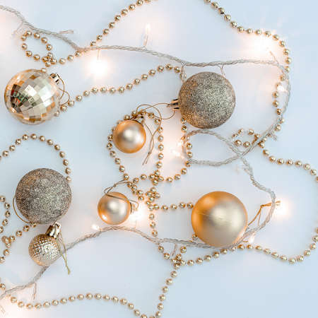 Christmas holidays composition, top view of gold Christmas decorations and garland with lights on a yellow background with copy space for text. Blur. Flat lay. Winter, postcard template.の写真素材