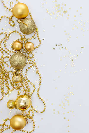 Christmas holidays composition, top view of gold Christmas decorations and garland with lights on a yellow background with copy space for text. Blur. Flat lay. Winter, postcard template.の写真素材