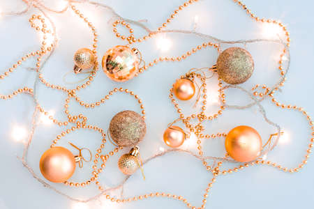 Christmas holidays composition, top view of gold Christmas decorations and garland with lights on a yellow background with copy space for text. Blur. Flat lay. Winter, postcard template.の写真素材