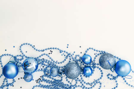 Christmas holidays composition, top view of blue Christmas decorations and garland with lights on a yellow background with copy space for text. Blur. Flat lay. Winter, postcard template.の写真素材