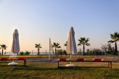 Empty volleyball court with a net at sunset with palm trees and the sea in the Turkish hotel.の写真素材