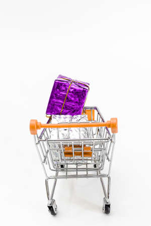 Grocery cart with New Year's holiday gifts on a white isolated plain background. Flat lay. Save the space. Postcard Template.の写真素材
