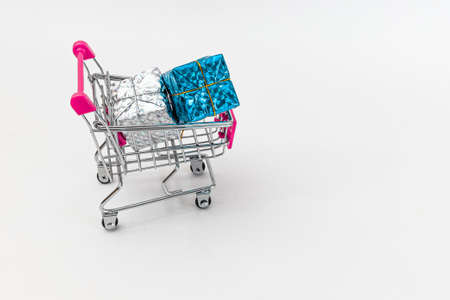 Grocery cart with New Year's holiday gifts on a white isolated plain background. Flat lay. Save the space. Postcard Template.の写真素材