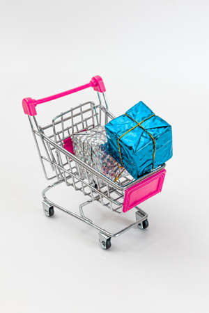 Grocery cart with New Year's holiday gifts on a white isolated plain background. Flat lay. Save the space. Postcard Template.の写真素材