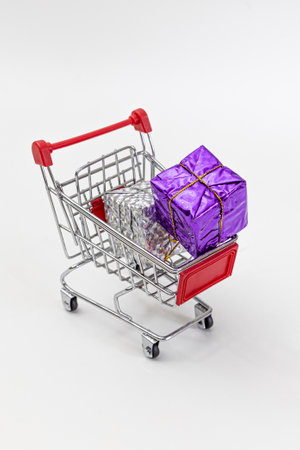 Grocery cart with New Year's holiday gifts on a white isolated plain background. Flat lay. Save the space. Postcard Template.の写真素材