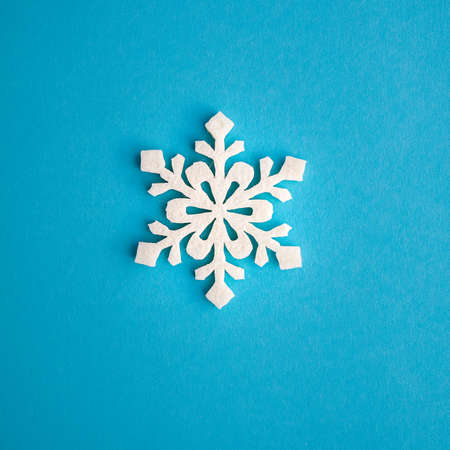 Christmas holidays composition, top view white snowflakes decoration on a blue-aquamarine background with copy space for text. Flat lay. Winter, postcard template.の写真素材