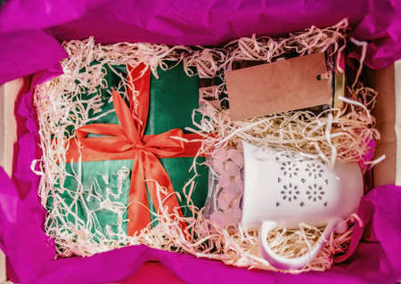 the gift box with shavings contains another gift and a cup with a gift card. copy space. View from aboveの写真素材