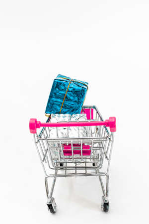 Grocery cart with New Year's holiday gifts on a white isolated plain background. Flat lay. Save the space. Postcard Template.の写真素材