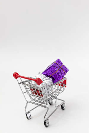 Grocery cart with New Year's holiday gifts on a white isolated plain background. Flat lay. Save the space. Postcard Template.の写真素材