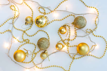 Christmas holidays composition, top view of gold Christmas decorations and garland with lights on a yellow background with copy space for text. Blur. Flat lay. Winter, postcard template.の写真素材