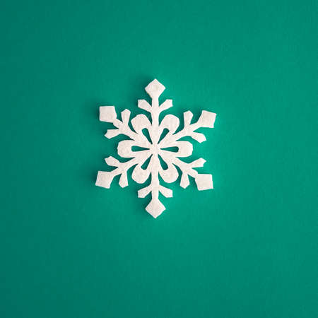 Christmas holidays composition, top view white snowflakes decoration on green and aquamarine background with copy space for text. Flat lay. Winter, postcard template.の写真素材
