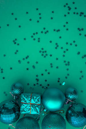 Christmas holidays composition, top view colored green and aquamarine Christmas decorations on green background with copy space for text. Flat lay. Winter, postcard template.の写真素材