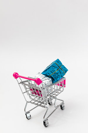 Grocery cart with New Year's holiday gifts on a white isolated plain background. Flat lay. Save the space. Postcard Template.の写真素材