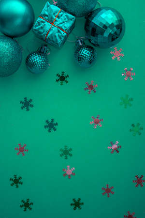 Christmas holidays composition, top view colored green and aquamarine Christmas decorations on green background with copy space for text. Flat lay. Winter, postcard template.の写真素材