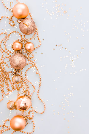 Christmas holidays composition, top view of gold Christmas decorations and garland with lights on a yellow background with copy space for text. Blur. Flat lay. Winter, postcard template.の写真素材