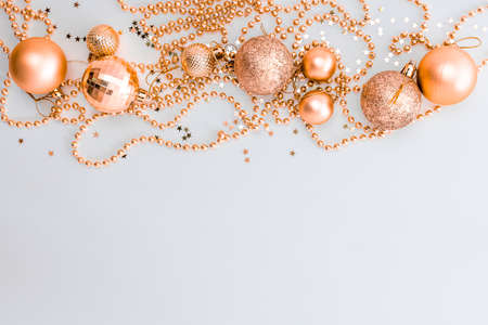 Christmas holidays composition, top view of gold Christmas decorations and garland with lights on a yellow background with copy space for text. Blur. Flat lay. Winter, postcard template.の写真素材