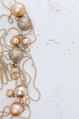 Christmas holidays composition, top view of gold Christmas decorations and garland with lights on a yellow background with copy space for text. Blur. Flat lay. Winter, postcard templateの写真素材